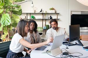 Coworkers in an office looking at a computer screen.