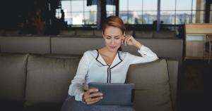 A happy woman using Splashtop on her iPad to remotely access her Mac computer.