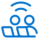 Blue icon showing two stylized people sitting next to each other, with curved lines above them resembling a wireless signal, on a light gray background.