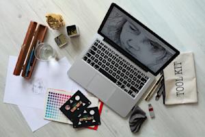 A laptop with graphic design software opened on a desk.