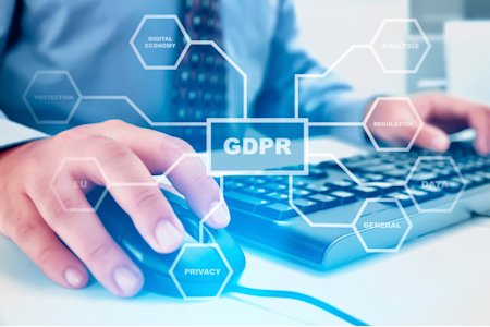 Professional using a computer with GDPR-related terms overlayed, symbolizing data protection and compliance.