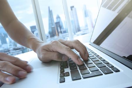 Image of a person typing on their laptop