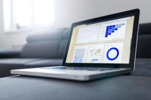 A laptop with the screen displaying analytics charts