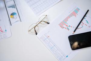 Report printouts scattered on a desk.