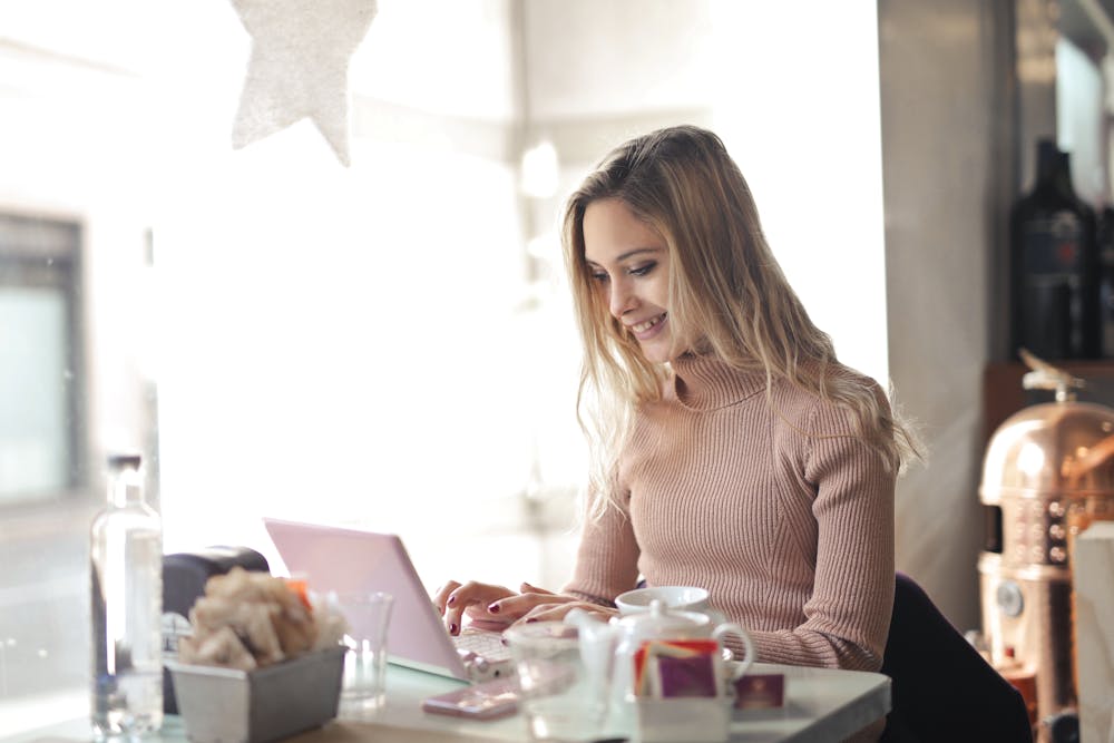 A woman smiling while using Splashtop on her laptop to work remotely.