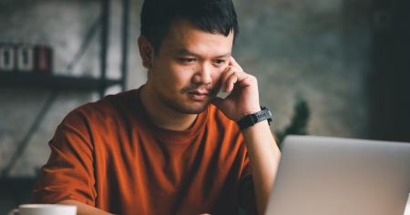 Man focused on reading article about Splashtop Remote Support SOS on computer screen