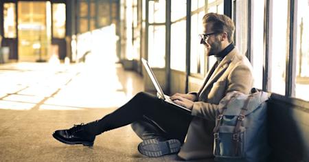 A man sitting and using his laptop to remotely access his Ubuntu desktop.