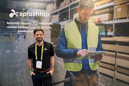 Man in Splashtop attire at an event, with promotional backdrop about remote support solutions