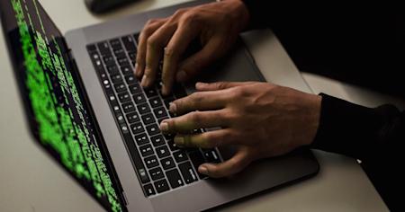 Hands typing on a laptop keyboard.