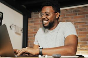 A smiling person working on a computer.
