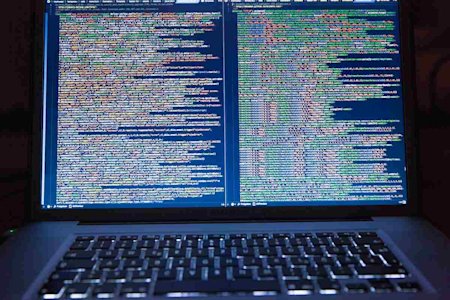 A laptop computer displaying multiple lines of code.
