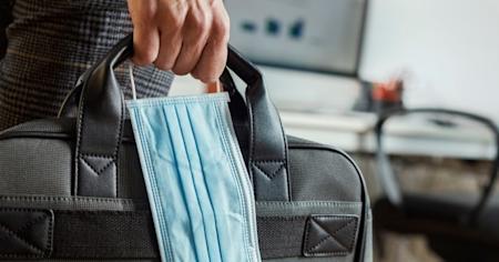 Man holding laptop case and mask