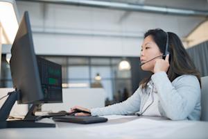 A woman providing remote tech support from her computer.