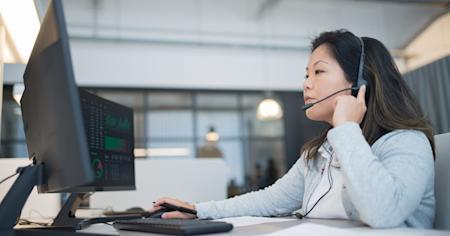 A woman providing remote tech support from her computer.