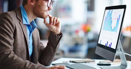 IT professional analyzing data on a computer screen, illustrating the importance of Remote Monitoring and Auditing for effective Remote Support.