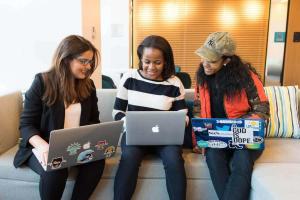 Three students sitting on a couch with their laptops using Splashtop for remote learning.