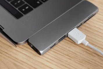 A Mac laptop with a USB device plugged in.