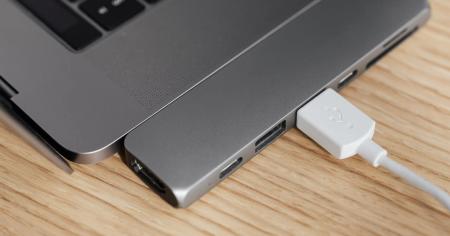 A Mac laptop with a USB device plugged in.