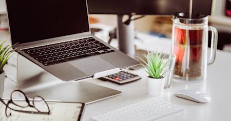 An office desk with a computer, keyboard, and other items.