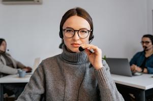 An IT support agent with a headset on in an office.
