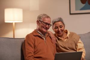And elderly man and woman using a laptop.