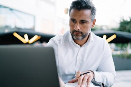 Man on computer reading why Splashtop is better than BeyondTrust