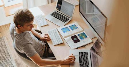 A man at his desk using a remote access program on his laptop