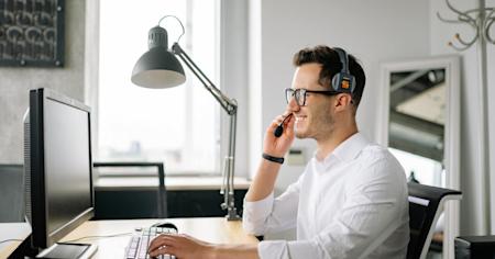 An IT service desk technician at their computer providing remote support to an end user.