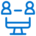 Blue icon of two people sitting across from each other at a table, representing a meeting or conversation.