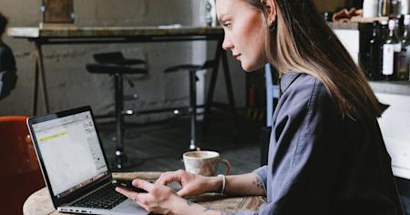 A woman using Splashtop to access her work computer remotely from her laptop at a coffee shop.