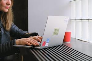 A person types on a laptop computer.