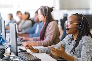 IT service desk team providing support at a computer workstation.