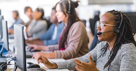 IT service desk team providing support at a computer workstation.