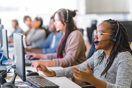 IT service desk team providing support at a computer workstation.