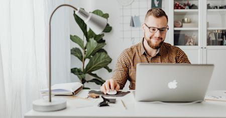 A man sitting at a desk using his laptop.