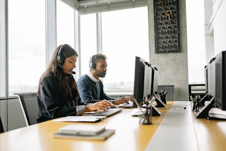 Two IT managers working at their computers.