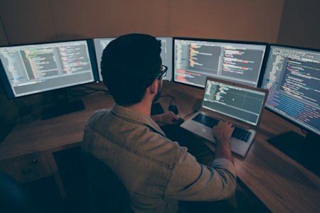 Man using computer with multiple screens