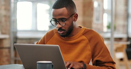 A man working on a laptop device.