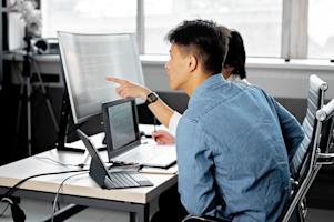 IT team members provide support to managed endpoints in an office.