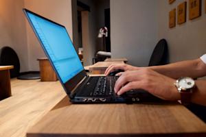 Hands typing on the keyboard of a laptop.