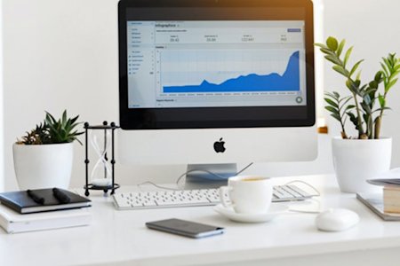 Mac desktop displaying graphs on the screen, showcasing the efficiency of remote work