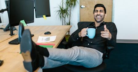 Man at desk with a smile, praising the benefits of hybrid work from home and office with Splashtop