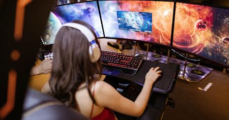 A person on a gaming computer with multiple displays.