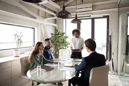 A team of four people discussing new ideas in a meeting room.