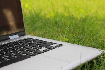 A laptop sitting on green grass