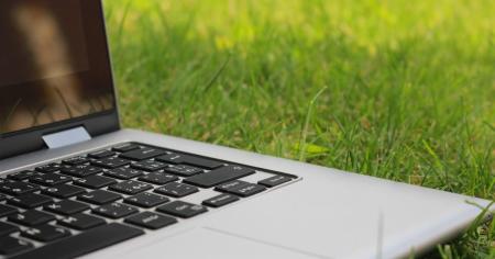 A laptop sitting on green grass
