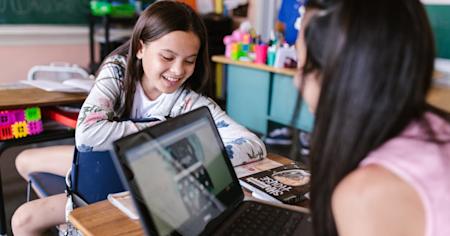 Students in a school classroom working on laptops.