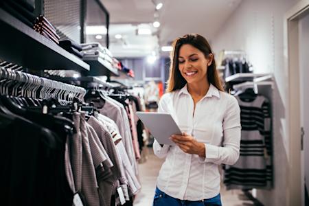 Woman using her tablet to remotely access her workstation to keep track of her store's inventory