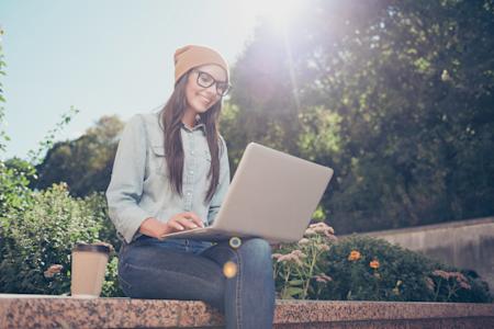 Smiling student using Splashtop on laptop outdoors