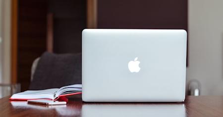 A Mac laptop on a desk.